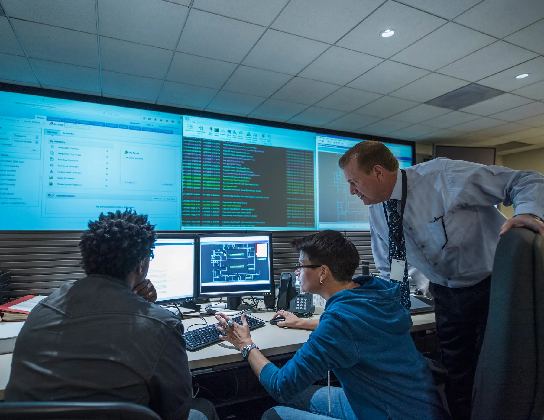 Technical team monitoring system health in an operations room